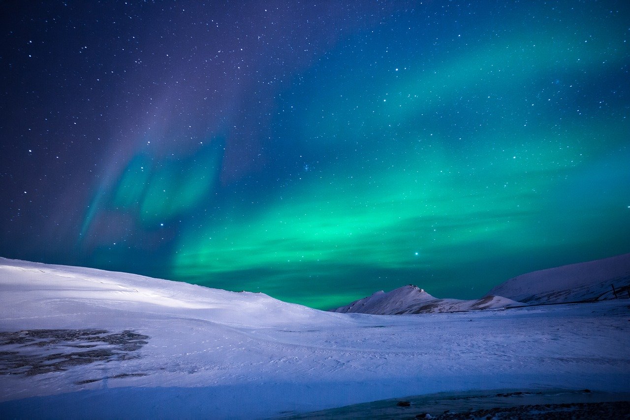 northern lights with snow in foreground