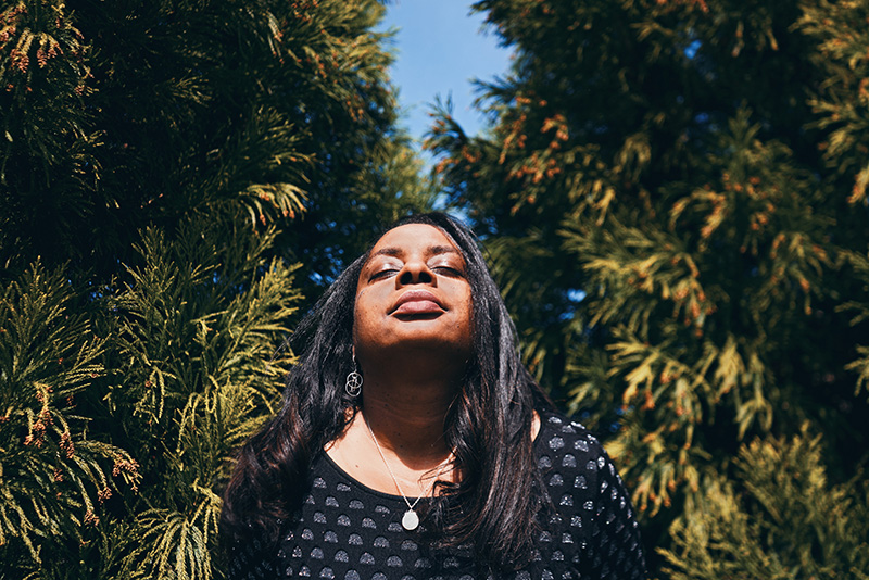 An image of a woman enjoying breathing in wild nature.